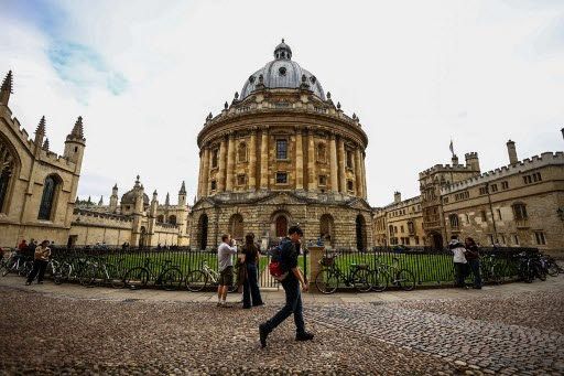 This photo taken on June 17, 2026 shows people walking past the Radcliffe Camera building at Oxford University in Oxford, central England. With its grand atrium, 500-seat acoustics-led concert hall and other state-of-the-art spaces, Oxford's Schwarzman Centre is the newest example of an elite UK university showcasing a billionaire's endowment. (Photo by HENRY NICHOLLS / AFP) / TO GO WITH Britain-education-universities-philanthrophy,FOCUS by Joe JACKSON