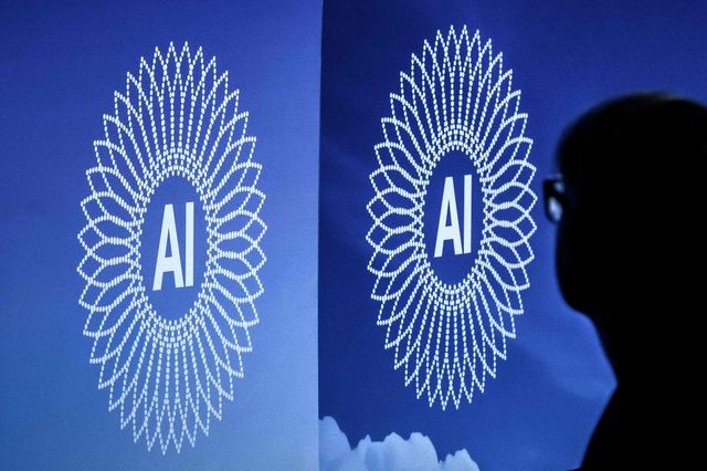 A person is silhouetted next to the logo of the first Global Dialogue on AI Governance, in Geneva on July 6, 2026. Guterres called for a global governance system to shape artificial intelligence for the good of humanity, warning against allowing the technology itself to 