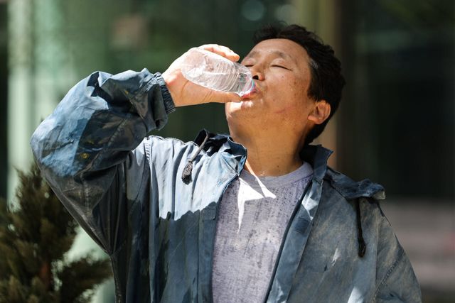 지난달 29일 서울 종로구 서울고용노동청 앞에서 열린 건설현장 실내공사 고열·폭염대책 시행 촉구 기자회견에서 한 건설노동자가 입고있던 분진복을 벗은 뒤 물을 마시고 있다.(사진=연합뉴스)