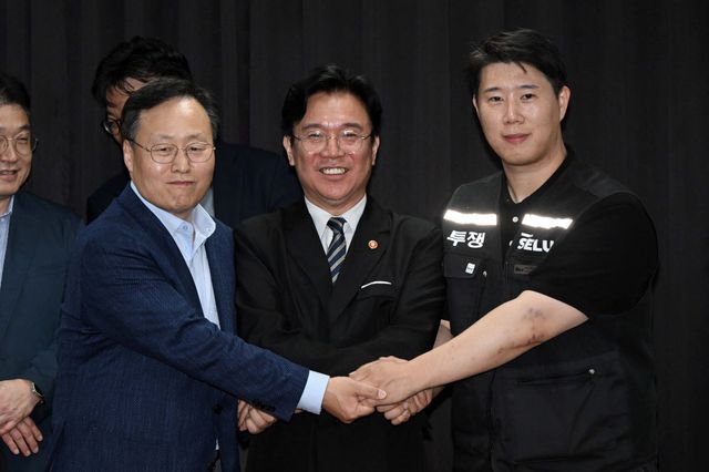 5월 20일 수원시 장안구 경기고용노동청에서 열린 삼성전자 임금협상을 마친 후 여명구 삼성전자 DS(반도체) 부문 피플팀장과 최승호 삼성그룹 초기업노동조합 삼성전자지부 위원장이 잠정 합의안에 서명한 후 김영훈 고용노동부 장관과 기념촬영을 하고 있다. (사진=연합뉴스)