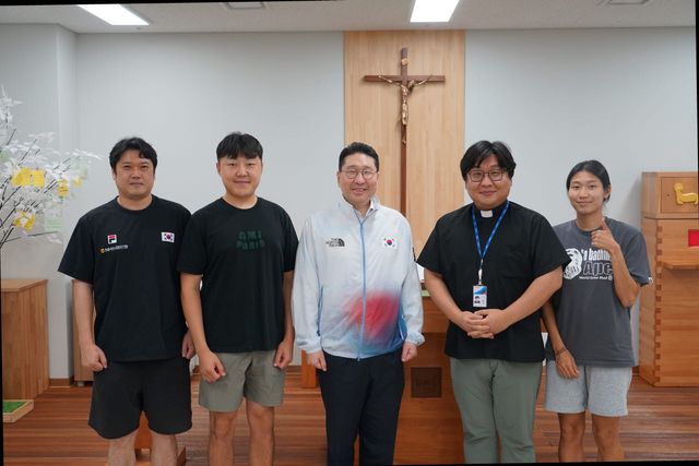 이상현 단장이 정구용 마르코 신부 및 국가대표 선수들과 함께 기념촬영을 하고 있다. 사진=대한사이클연맹