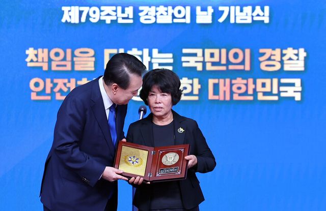 윤석열 대통령이 21일 서울 서대문구 경찰청 참수리홀에서 열린 79주년 경찰의 날 기념식에서 고(故) 이재현 경장의 모친 유진숙 씨에게 '경찰 영웅패'를 전달하고 있다. [사진=연합뉴스]