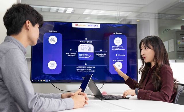 SK텔레콤과 삼성전자 연구원이 AI 기반 5G 기지국 품질 최적화 기술 실증에 대해 논의하는 모습. [사진=SKT]