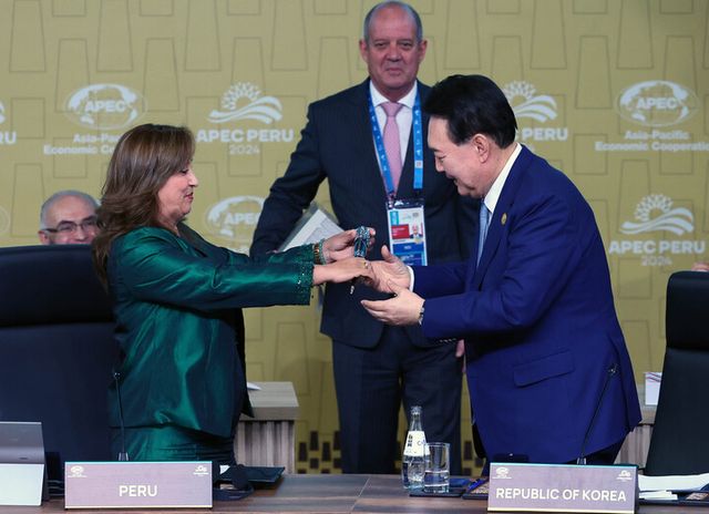 윤석열 대통령이 16일(현지 시각) 페루 리마 컨벤션센터에서 열린 31차 아시아태평양경제협력체(APEC) 정상회의 제2세션 리트리트를 마친 뒤 디나 볼루아르테 페루 대통령으로부터 의사봉을 넘겨받고 있다. [사진=연합뉴스]