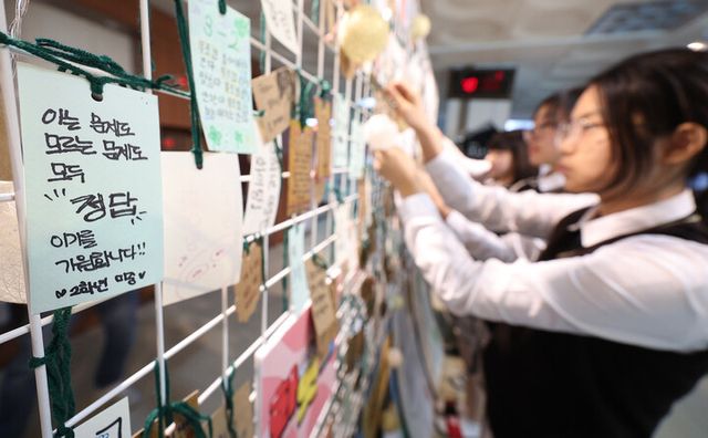 2025학년도 대학수학능력시험을 일주일 앞둔 7일 오전 대구 북구 매천고등학교 교정에서 2학년 학생들이 수능 응원 부적을 게시판에 달고 있다. [사진=연합뉴스]