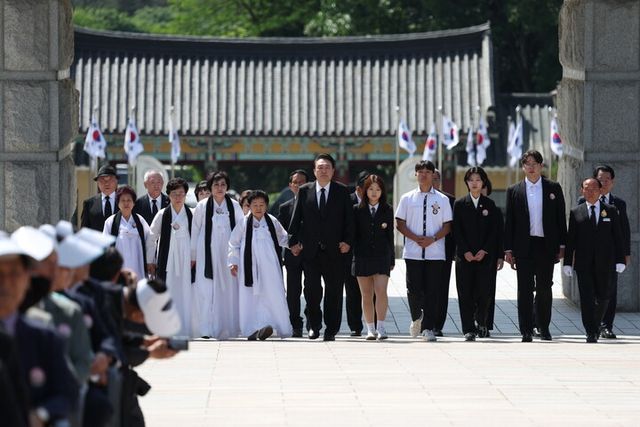 윤석열 대통령이 18일 광주시 북구 국립5·18민주묘지에서 열린 제44주년 5·18민주화운동 기념식에서 5·18 유가족 대표들과 함께 '민주의 문'으로 동반 입장하고 있다. [사진=연합뉴스]