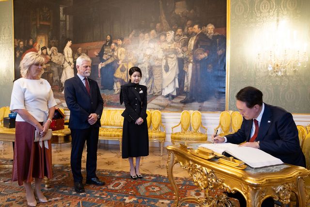 윤석열 대통령이 19일(현지 시각) 체코 프라하성 대통령궁에서 페트르 파벨 체코 대통령 부부가 지켜보는 가운데 방명록을 작성하고 있다. [사진=공동취재/연합뉴스]