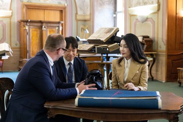 윤석열 대통령의 체코 방문에 동행한 김건희 여사가 20일(현지 시각) 프라하 체코국립도서관에서 열린 한·체코 국립도서관 고서 복원 시연회에 참석, 토마쉬 폴틴 체코국립도서관 관장에게 우리 한지(韓紙)의 우수성을 알리며 평소 사용하는 한지로 만든 가방을 소개하고 있다. [사진=공동취재/연합뉴스]