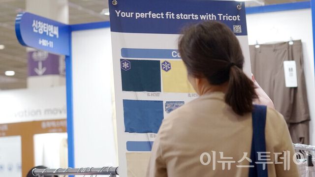 서울 강남구 코엑스에서 열린 ‘프리뷰 인 서울 2025’ 행사장에 마련된 효성티엔씨 부스에서 한 방문객이 전시된 쿨 원단을 살펴보고 있다.&nbsp;[사진=이뉴스투데이DB]