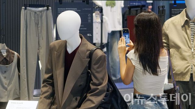 서울 강남구 코엑스에서 열린 ‘2025 트렌드페어’에 마련된 ‘올 인 코리아’ 부스에서 한 방문객이 전시된 옷을 촬영하고 있다.&nbsp; [사진=이뉴스투데이DB]