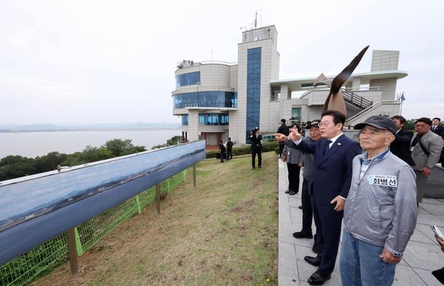 이재명 대통령이 3일 인천 강화군 강화평화전망대에서 북한 황해북도 개풍군 일대를 바라보며 실향민들과 이야기를 나누고 있다. [사진=연합뉴스]