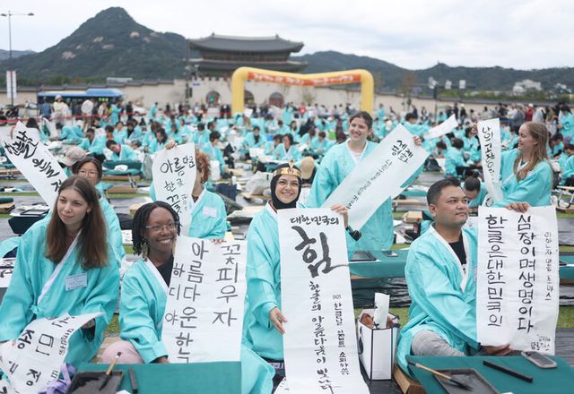 &nbsp;9일 광화문광장에서 열린 한국예술문화원 주최로 열린 ‘한글창제 579주년 기념 휘호대회’에 참가한 외국인들이 직접 붓으로 쓴 한글을 들어보이고 있다. [사진=연합뉴스]