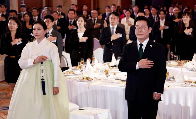 아랍에미리트(UAE)를 국빈 방문 중인 이재명 대통령과 김혜경 여사가 17일(현지 시각) 아부다비의 한 호텔에서 열린 동포만찬간담회에서 국기에 경례하고 있다. [사진=연합뉴스]