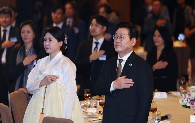 이집트를 공식 방문 중인 이재명 대통령과 김혜경 여사가 20일(현지 시각) 카이로의 한 호텔에서 열린 동포ㆍ지상사 간담회에서 국기에 경례하고 있다. [사진=연합뉴스]