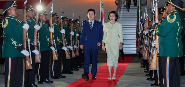 주요 20개국(G20) 정상회의에 참석하는 이재명 대통령이 김혜경 여사와 함께 21일(현지 시각) 남아프리카공화국 요하네스버그 OR탐보국제공항에 도착한 뒤 공군 1호기에서 내려 이동하고 있다. [사진=연합뉴스]