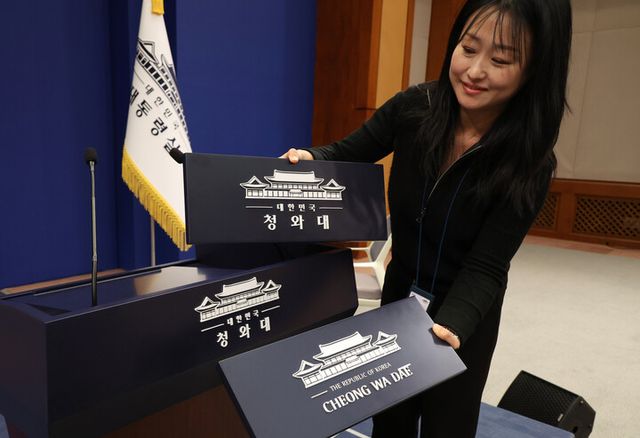 용산 대통령실 이전 작업을 본격화한 21일 청와대 브리핑룸에서 직원이 탈부착 업무표장을 설치하고 있다. [사진=연합뉴스]