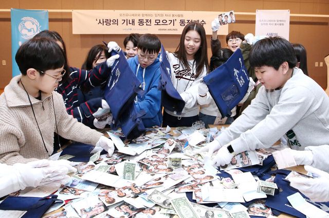20일 서울 강서구 아시아나항공 교육훈련동에서 임직원 자녀들이 ‘사랑의 기내 동전 모으기 캠페인’으로 모인 동전을 분류하고 있다. [사진=아시아나항공]
