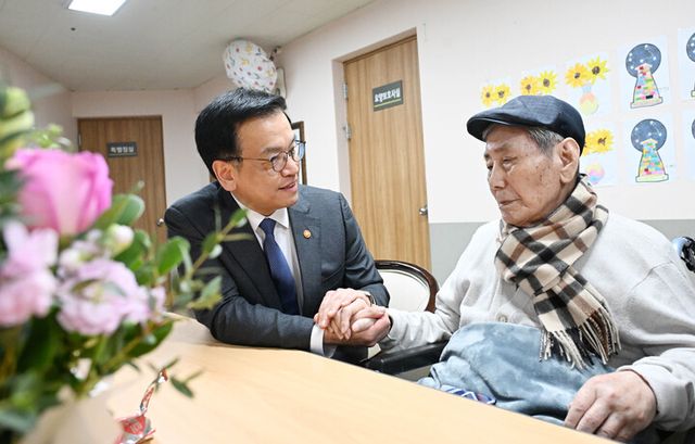 최상목 대통령 권한대행 부총리 겸 기획재정부 장관이 21일 수원보훈원에서 항일애국지사 오성규 애국지사를 위문하며 손을 잡고 있다. [사진=기획재정부]