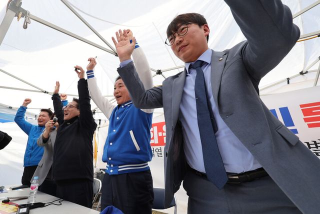 26일 서울 광화문 더불어민주당 천막 당사에서 더불어민주당 모경종(오른쪽부터), 박용갑, 박선원 의원이 이재명 대표 공직선거법 위반 혐의 항소심 무죄 소식을 들은 뒤 만세를 외치고 있다. [사진=연합뉴스]