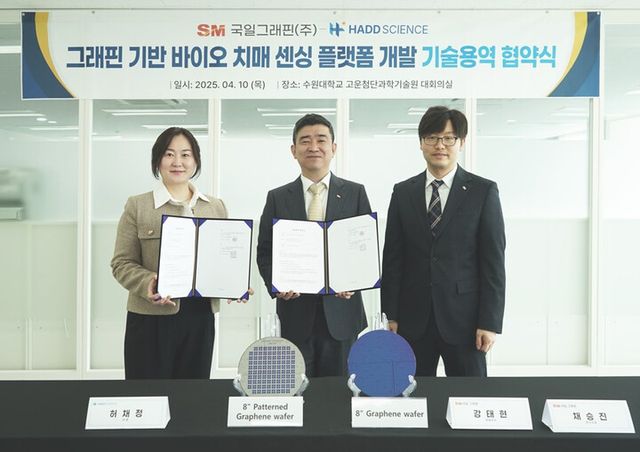 강태현 국일그래핀 대표(가운데)와 채승진 상무(오른쪽)가 지난 10일 경기 화성시 수원대학교 고운첨단과학기술원에서 허채정 하드사이언스 대표와 그래핀 기반 바이오 치매 진단 플랫폼 개발 기술용역 계약을 체결한 뒤 기념촬영을 하고 있다. 8인치 실리콘 가판 위에 전사된 그래핀 샘플이 테이블에 놓여 있다. [제공=SM그룹]
