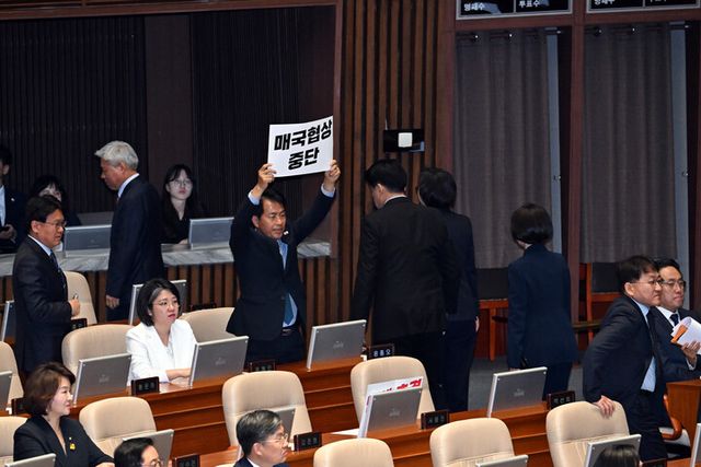 윤종오 진보당 의원이 24일 서울 여의도 국회 본회의장에서 한덕수 대통령 권한대행 국무총리의 추가경정예산안 시정연설 때 항의 팻말을 들어보이고 있다. [사진=연합뉴스]