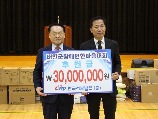 강세훈 한국서부발전 기획본부장(오른쪽)과 이종만 태안지체장애인협회장이 기념 촬영하는 모습. [사진=한국서부발전]