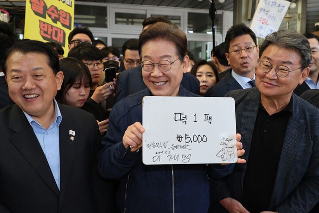 이재명 더불어민주당 대선 후보가 '골목골목 경청투어' 접경지역 방문 이틀째인 2일 강원도 철원군 동송전통시장에서 한 떡집에 들러 가격판에 사인을 해준 뒤 활짝 웃고 있다. [사진=연합뉴스]