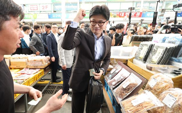 한동훈 국민의힘 대선 경선 후보가 2일 경남 창원시 마산합포구 마산어시장에서 김 등을 구매 후 손을 들어 시장 상인을 응원하고 있다. [사진=연합뉴스]