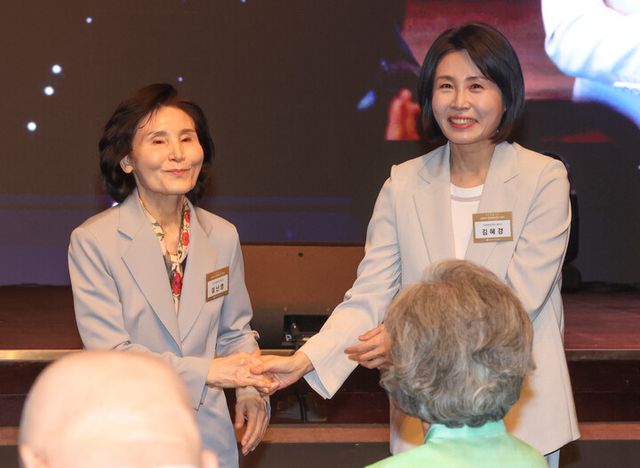 김문수 국민의힘 대선 후보의 부인 설난영 씨와 이재명 더불어민주당 대선 후보의 부인 김혜경 씨가 12일 서울 중구 신라호텔에서 열린 중앙신도회 창립 70주년 기념식에서 손을 잡고 인사하고 있다. [사진=연합뉴스]