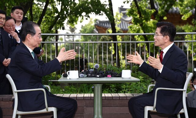 김문수 국민의힘 대선후보와 한덕수 무소속 대선 예비후보가 8일 서울 국회 사랑재 야외에서 만나 대화하고 있다. [사진=연합뉴스]