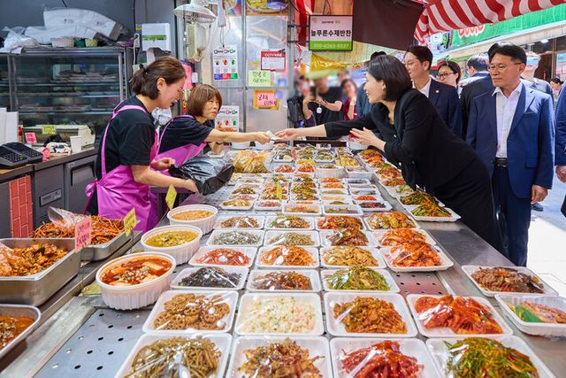 김혜경 여사가 6일 서울 동작구 남성시장을 방문해 한 상점에서 식품을 구매하고 있다. [사진=대통령실]