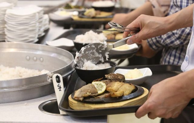 서울 종로구 정부서울청사 구내식당에서 직원들이 ‘수산물데이’를 맞이해 준비된 모둠 생선구이로 점심을 먹기 위해 배식받고 있다. [사진=연합뉴스]