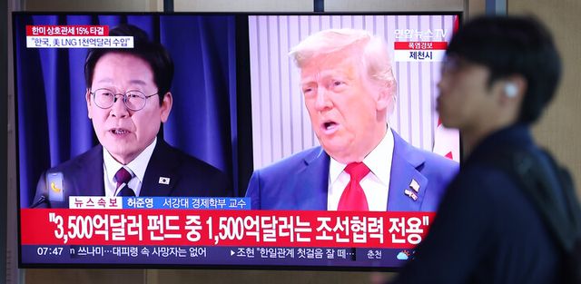 한국과 미국의 관세협상이 타결된 31일 서울역 대합실에서 한 시민이 관련 뉴스가 나오는 TV 앞을 지나고 있다. [사진=연합뉴스]