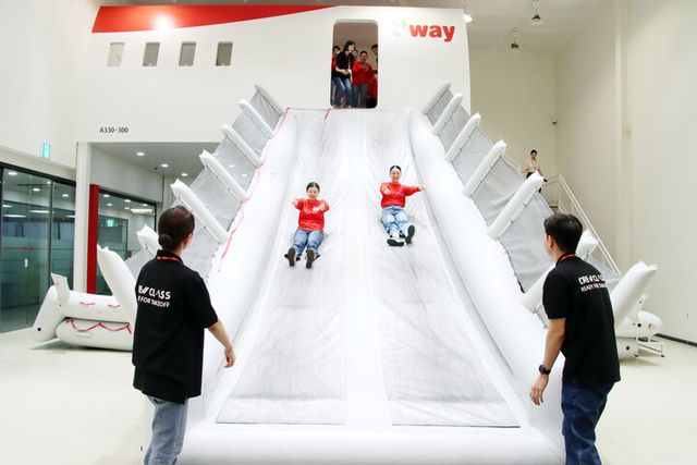 지난 7일(목) 티웨이항공 훈련센터에서 객실 승무원 체험과정 '크루클래스'에 참여한 일본 대학교 학생들이 A330 항공기 슬라이드 훈련을 체험하고 있다.&nbsp;[사진=티웨이항공]