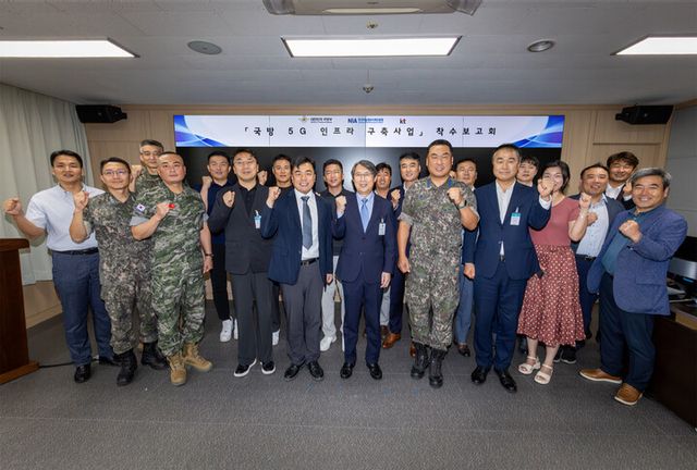 KT Enterprise부문 이행1본부장 이진권 상무(앞줄 왼쪽부터 6번째)와 국방부, 한국지능정보사회진흥원(NIA) 주요 관계자가 ‘국방 5G 인프라 구축’ 사업 착수보고회에서 단체 기념사진을 촬영하는 모습 [사진=KT]