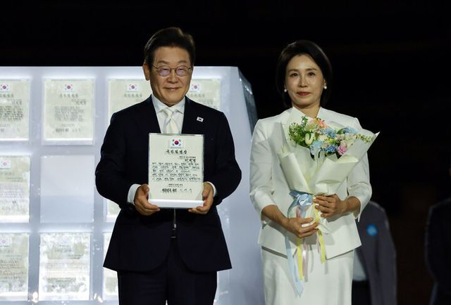 이재명 대통령과 김혜경 여사가 15일 서울 세종대로 광화문광장에서 열린 제21대 대통령 국민임명식 '광복 80년, 국민주권으로 미래를 세우다' 행사에서 국민 대표 80인으로부터 '빛의 임명장'을 받은 뒤 감사 인사를 하고 있다. [사진=연합뉴스]