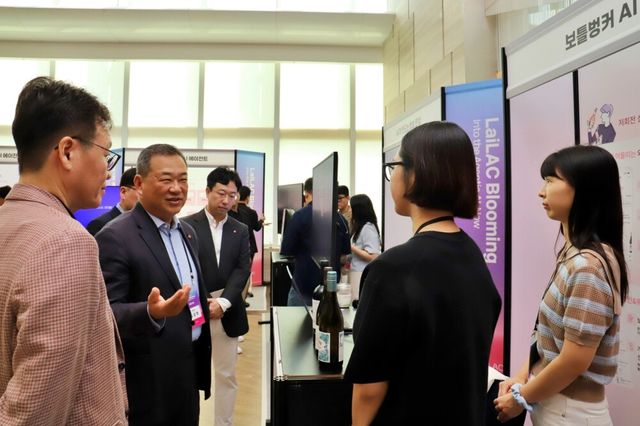 김상현 롯데 유통군 총괄대표 부회장(왼쪽에서 두번째)이 ‘AI 혁신 사례’ 전시를 살펴보고 있다.[사진=롯데유통군]