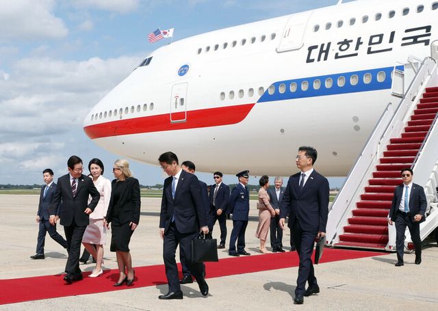 이재명 대통령이 24일(현지 시각) 미국 워싱턴DC 인근 앤드루스 합동기지에 공군1호기로 도착해 미국 측 애비 존스 부의전장과 대화하며 기지를 빠져나가고 있다. [사진=연합뉴스]