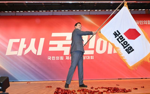 장동혁 국민의힘 신임 당 대표가 26일 서울 여의도 국회도서관에서 열린 제6차 전당대회 결선에서 당 대표로 선출된 뒤 당기를 흔들고 있다 [사진=연합뉴스]