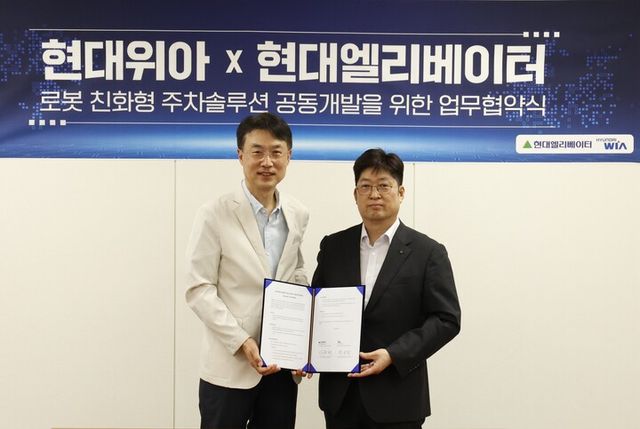 현대위아 모빌리티솔루션사업부 백익진 상무(왼쪽)와 현대엘리베이터 승강기사업본부장 이원해 상무가 28일 경기도 의왕시 현대위아 의왕연구소에서 열린 ‘로봇 친화형 주차솔루션 공동개발을 위한 업무협약식’에서 기념 사진을 찍고 있다. [사진=현대위아]