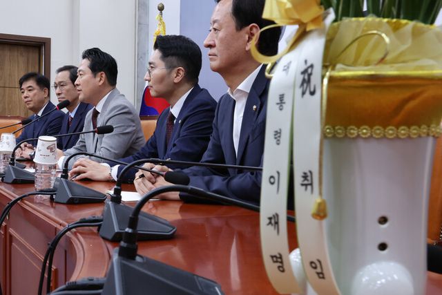 우상호 대통령실 정무수석이 27일 서울 여의도 국회에서 국민의힘 장동혁 신임 대표를 예방하고 있다. 회의장 탁자 위에 이재명 대통령이 우 수석을 통해 보낸 축하난이 놓여 있다. 2025.8.27