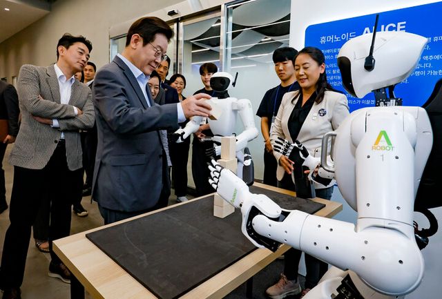 이재명 대통령이 17일 경기도 성남시 스타트업 스퀘어에서 컵 쌓기 퍼포먼스를 선보인 휴머노이드 로봇을 살펴보고 있다. [사진=연합뉴스]