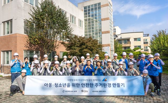 봉사활동에 참여한 대한항공-아시아나항공 양사 임직원 20여 명이 노후화된 벽지 교체 등을 지원하고 기념사진을 촬영하는 모습. [사진=대한항공]