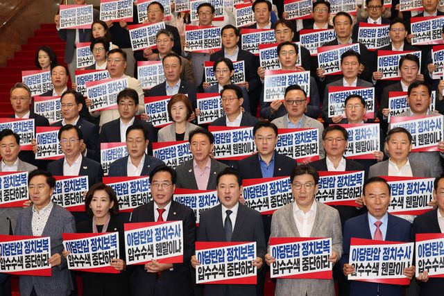 장동혁 대표, 송언석 원내대표 등 국민의힘 의원들이 3일 서울 여의도 국회에서 열린 의원총회를 마치고 '야당탄압 정치보복 압수수색 중단하라'라고 적힌 손팻말을 들고 피케팅을 하고 있다. [사진=연합뉴스]