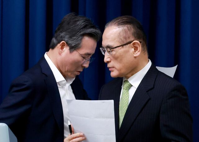 김용범 대통령실 정책실장(왼쪽)과 위성락 국가안보실장이 지난해 7월 25일 서울 용산 대통령실 청사에서 이날 강훈식 대통령비서실장 주재로 열린 통상대책회의 관련 브리핑에 대한 취재진의 질문에 답하기 위해 마이크 앞 자리를 바꾸고 있다. [사진=연합뉴스]