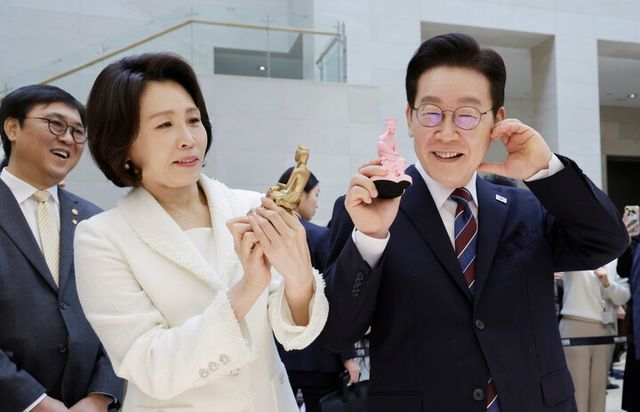 이재명 대통령과 김혜경 여사가 26일 서울 용산구 국립중앙박물관에서 열린 특별전 '우리들의 이순신'을 관람한 뒤 상품관에서 기념품과 함께 기념촬영을 하고 있다. [사진=연합뉴스]