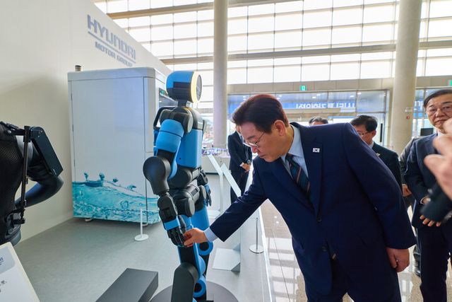 이재명 대통령이 27일 전북 군산새만금컨벤션센터에서 열린 새만금 로봇·수소·AI 시티 투자협약식에 앞서 전시된 아틀라스 로봇을 살펴보고 있다. [사진=연합뉴스]