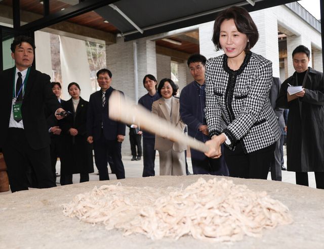 김혜경 여사가 27일 전북 전주천년한지관에서 닥나무 껍질을 닥돌 위에서 두드리고 있다. [사진=연합뉴스]