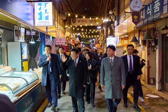 이재명 대통령이 9일 저녁 식사를 위해 방문한 서울 종로구 통인시장에서 상인들에게 인사하고 있다. [사진=청와대]