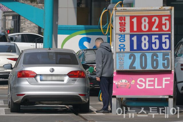 5일 서울 서초구의 한 주유소에 설치된 유류 가격 안내판 뒤로 고객이 주유하고 있다. [사진=안경선 기자]